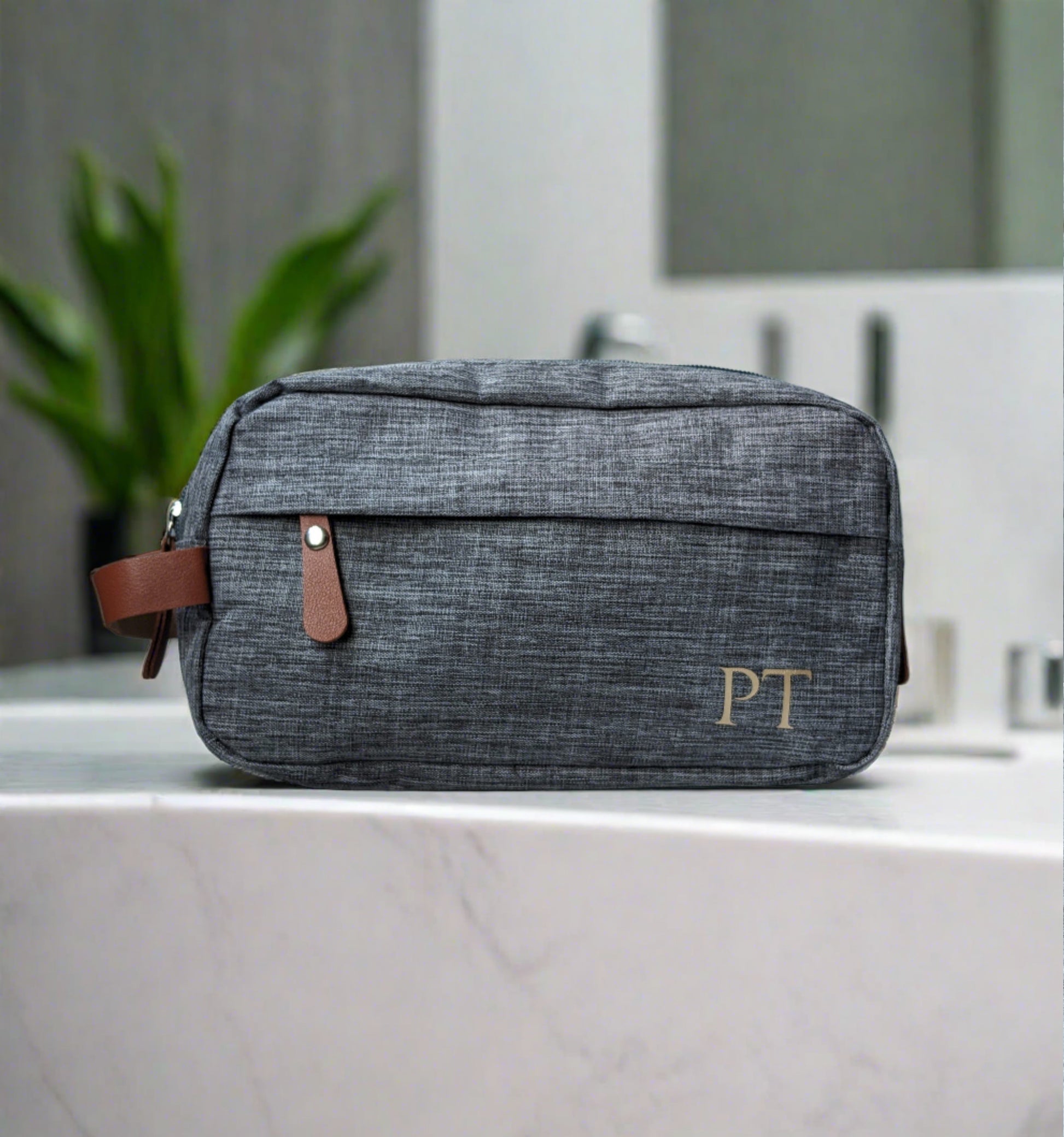 Men's grey toiletries bag with brown accents. Monogramed initials in gold on the bottom right corner https://wattlelanedesigns.com.au/products/copy-of-mens-monogramed-toiletries-bag-grey