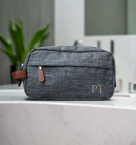 Men's grey toiletries bag with brown accents. Monogramed initials in gold on the bottom right corner https://wattlelanedesigns.com.au/products/copy-of-mens-monogramed-toiletries-bag-grey